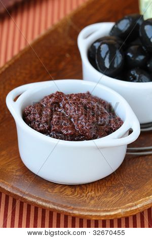 Vorspeise von Oliven, Tapenade auf einem Holzbrett