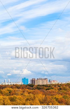 White Clouds In Blue Sky Over Yellow City Park On Sunny Autumn Day