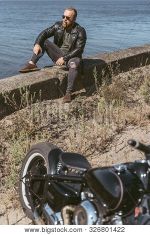 Attarctive Bearded Man Sitting By The Roadside Enjoying The View Of The Ocean
