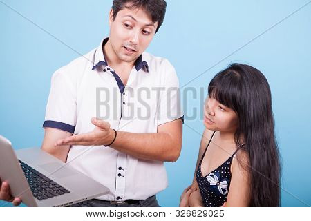 Cacausian Male Showing His Asian Girlfriend Something On His Computer
