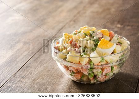 Traditional Russian Salad In Bowl. Olivier Salad On Wooden Table. Copy Spacce