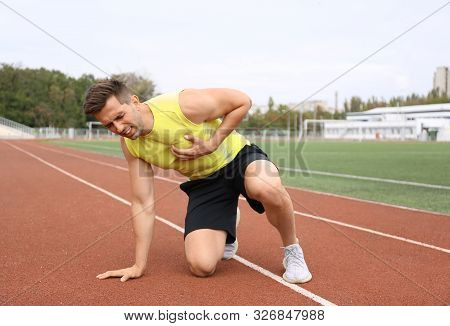 Young Man Having Heart Attack While Running At Stadium