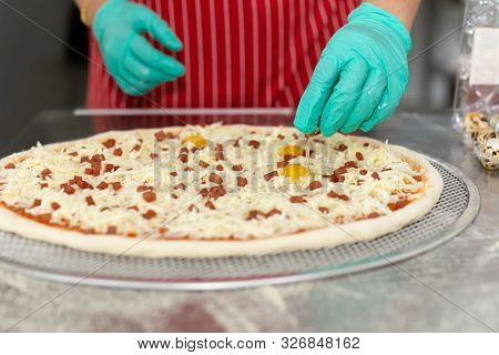 Chefs Hand Preparing Pizza On Kitchen Table Top With Quail Egg,