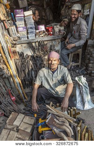 New Delhi, India - Nov 17, 2011: Man Sits In Front Of His Tooling Shop At The Street In Old Delhi, C