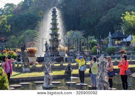 Bali, Indonesia - 17 September 2019: People praying on the stepstones of Tirtagangga Water Palace in Bali, Indonesia