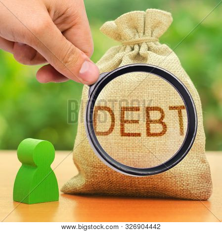 A Magnifying Glass Looks At A Bag With The Inscription Debt. Unclosed Obligations Between Two Person