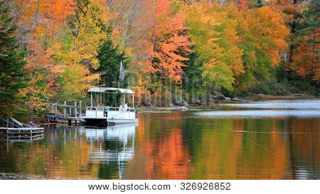 A boat in Ricker pond in Vermont with fall foliage