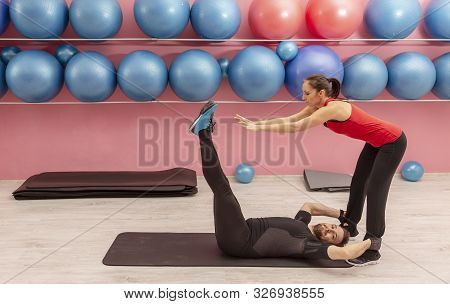 Young Man Helped By His Coach Doing Stretching Exrcises In A Gym.