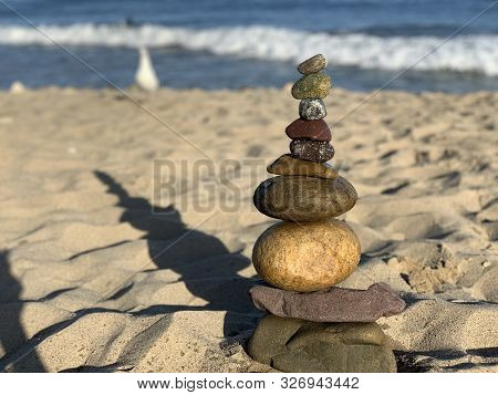Pebbles Stacked On Malibu Beach At Pacific Ocean