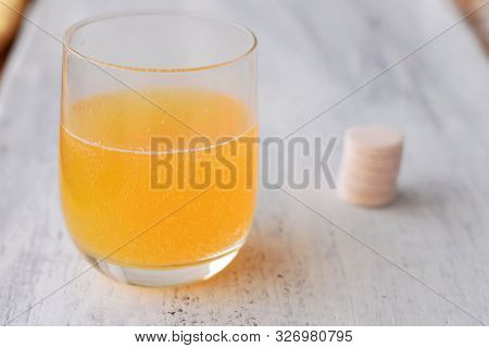 Effervescent Tablet On White Background And Orange Effervescent Bubbles Of Calcium And Vitamin C Eff