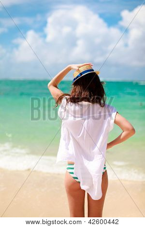 Giovane donna bella, camminando sulla spiaggia tropicale