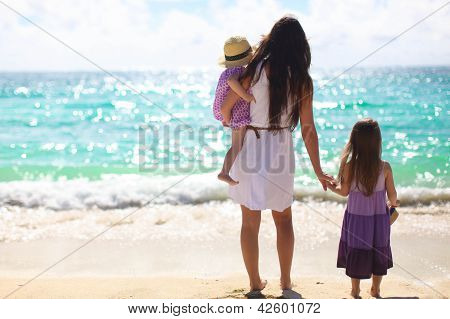 Madre e due bambini in spiaggia giorno pieno di sole