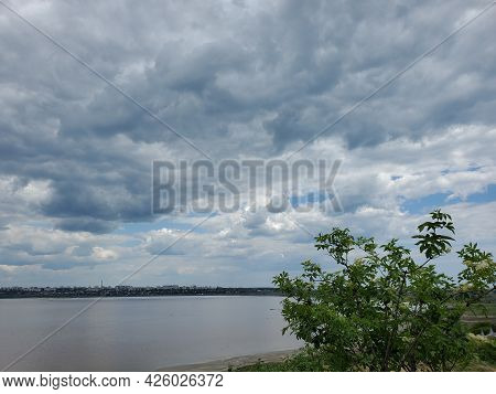 High Overcast Sky With White Fluffy Cumulus Clouds Floating In Wind. Tranquil Cloudscape Over Calm W