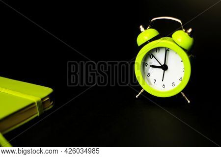Alarm Clock Morning Wake-up Time. Light Green Alarm Clock On A Black Background. Time Minimalistic C