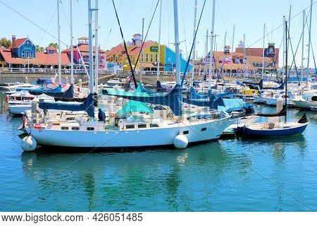July 6, 2021 In Long Beach, Ca:  Sailboats And Yachts Docked With Colorful Colonial Style Buildings 