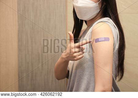 Healthy Asian Woman Concept Of Recommended Inoculation,  Woman Holding Down Her Shirt Sleeve And Sho