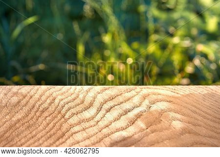 Wooden Texture, Smooth Oak Surface, Grass In The Background Out Of Focus, Close-up.
