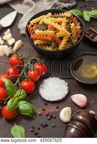 Fusilli Tricolor Pasta With Parmesan And Tomatoes, Parmesan Cheese And Tomatoes On Wooden Table Back