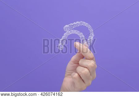 Close Up Of Woman's Hand Holding Invisalign Braces In Studio, Dental Healthcare And Orthodontic Conc