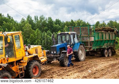 Vitebsk, Belarus, July 9 2020. Agricultural Machinery Compresses The Silage Mass Into A Trench. Harv