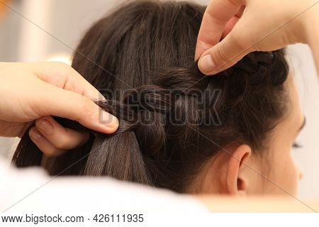Professional Stylist Braiding Client's Hair On Blurred Background, Closeup