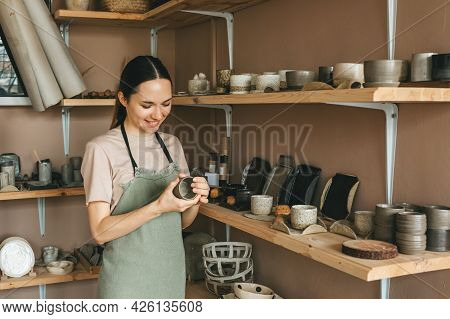 The Potter Woman Checks The Finished Ceramic Dishes. The Concept Of Small Business And Creativity