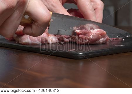 Slice The Pork Or Beef With A Knife On The Table In Close-up.preparation Of Meat Dishes And Food Pro