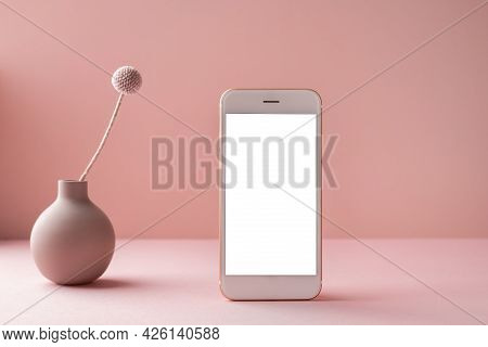 Mobile Phone With White Screen And Dry Flower In Vase On Pink Background With Dark Shadows. Trend, M