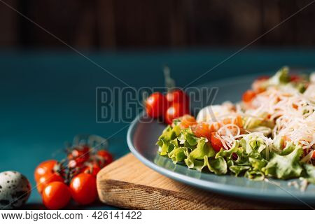 Blue Plate With Salad On The Table With Cherry Tomatoes