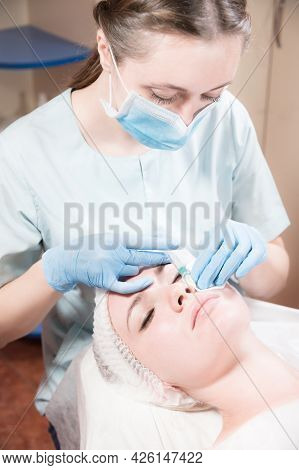 Cosmetology. Close-up Of The Beautician S Hand And The Patient S Face Before An Injection Of Hylauro