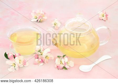 Apple blossom flower herbal tea high in antioxidants, beneficial for digestion, obesity, nervous system and skin ailments problems. Health care concept On pink marble.
