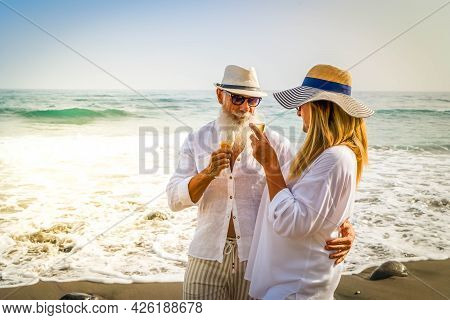 Lifestyle Of Caucasian Senior Couple Drinking Champagne On Beach, Happy In Love Romantic And Relax T