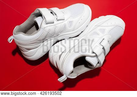 Top View Macro Set Pyramid Of Two White Children Sneakers With Velcro Fasteners For Comfortable Foot
