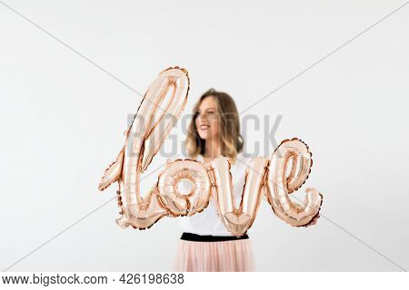 Woman holding a love foil balloon