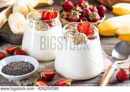 Fresh Yogurt With Strawberries, Banana, Chia Seeds On A Wooden Table, Delicious Dessert For Healthy 
