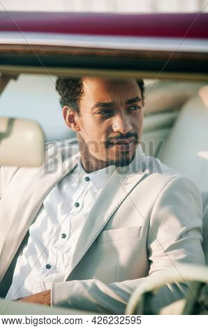 Young Black Man In Nature Posing With A Convertible. Looking Into The Distance
