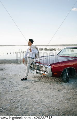 Young Black Man In Nature Posing With A Convertible. Sunset Portrait.