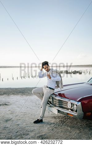 Young Black Man In Nature Posing With A Convertible. Sunset Portrait.