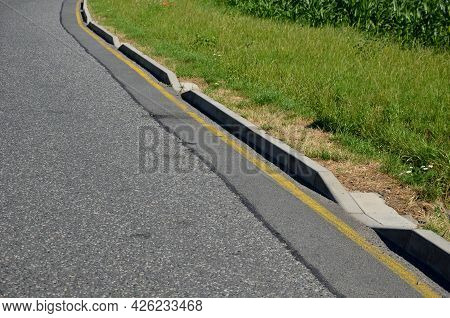 Installation Of Concrete Curbs With Gaps That Let Water Into The Park Into The Ditch, Where It Seeps