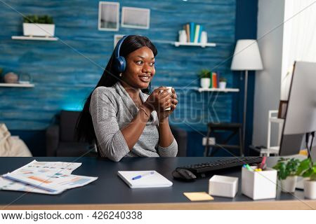 African American Student Holding Cup Of Coffee In Hands Wearing Headphones While Listening Modern Mu