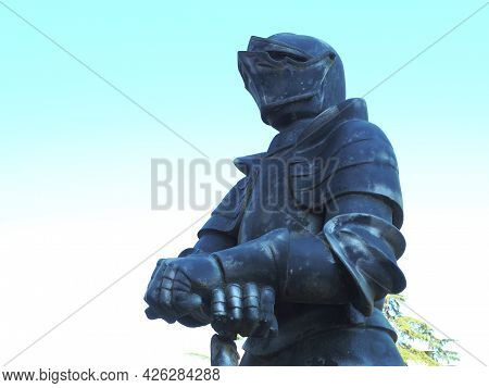 Russia, Dagomys 08.06.2021. Stone Statue Of A Medieval Knight In Armor Stands On The Street Against 