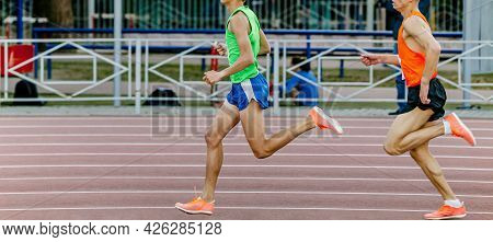 Two Male Athletes Runners Run At Stadium Track And Field Competition