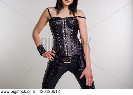A Beautiful Woman In A Leather Corset Poses