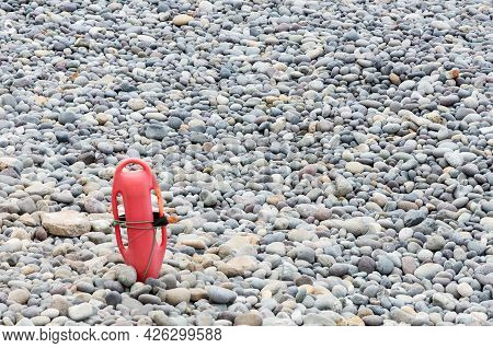 Red Plastic Buoyancy Aid In The Sand On Lonely Beach.