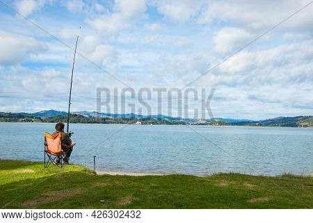 Whakatane New Zealand - May 26 2012; Lone Fisher At Ohiwa Harbour Rear View Patiently And Hopefully 