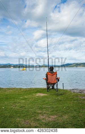 Whakatane New Zealand - May 26 2012; Lone Fisher At Ohiwa Harbour Rear View Patiently And Hopefully 