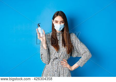 Covid-19, Social Distancing And Healthcare Concept. Beautiful Girl In Medical Mask Using Hand Sanizi