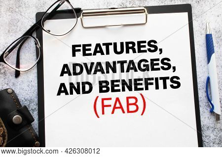 Business Acronym Fab - Feature Advantage Benefits. Text On A Sheet Of Notepad On A Black Envelope On