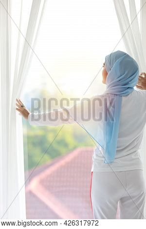 Rear View Beautiful Asian Muslim Woman Wearing White Sleepwear, Stretching Her Arms After Getting Up
