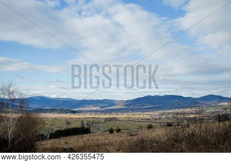 Idyllic Rural View Of Gently Rolling Patchwork Farmland And Villages With Pretty Wooded Boundaries,